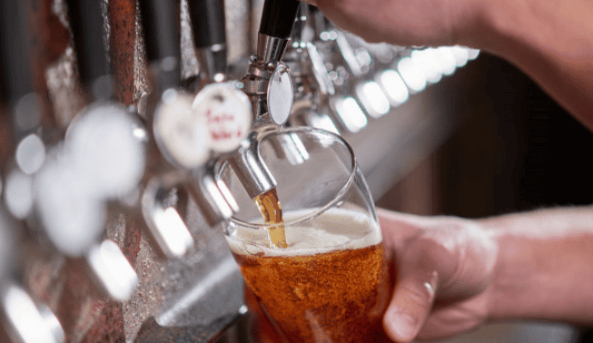 Beer being poured from a tap at a brewpub – protected by Crafted Insurance
